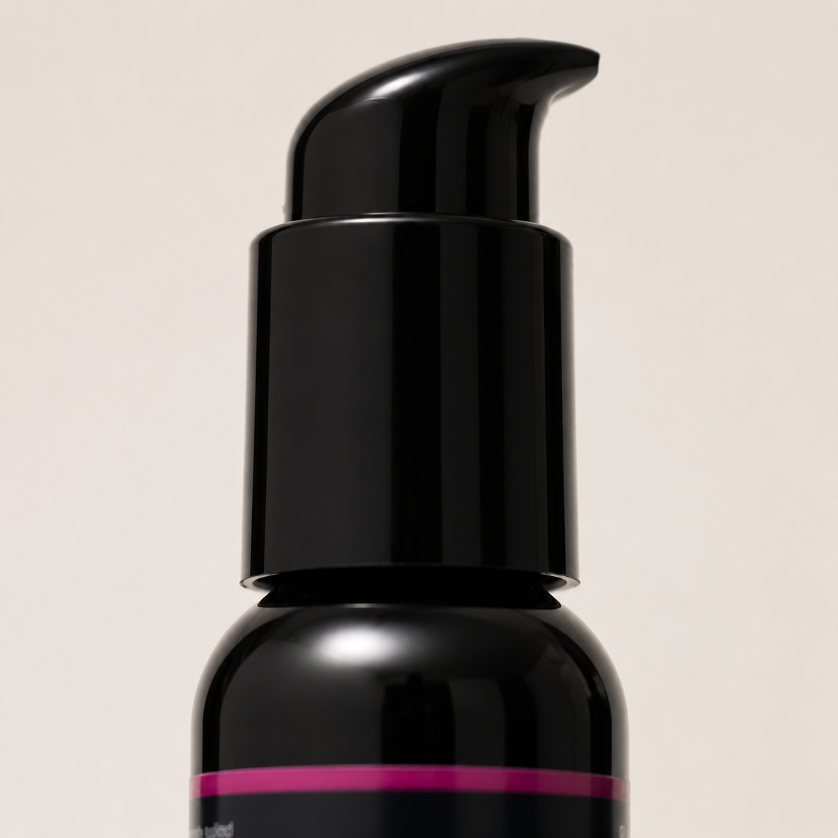 Macrodetail van de zwarte pomp en glossy flacon van FlexToyz vegan massageolie