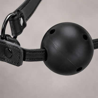 Detailfoto van de geventileerde siliconen bal en kunstleren band van de zwarte ball gag