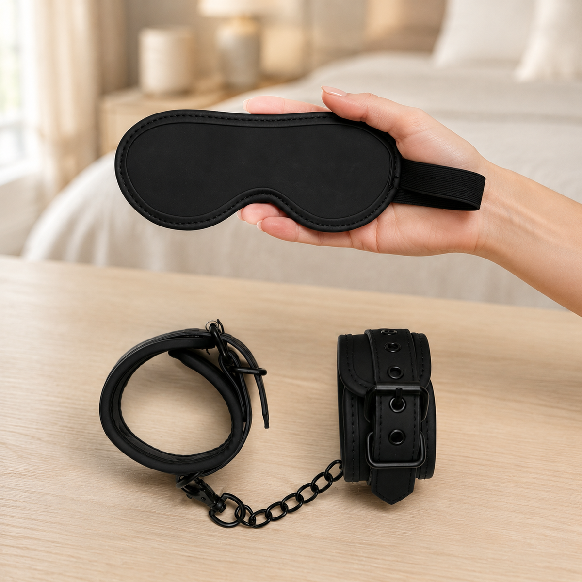 Hand toont het zwarte gevoerde oogmasker uit BondageKit 4 voor een duidelijk schaalbeeld