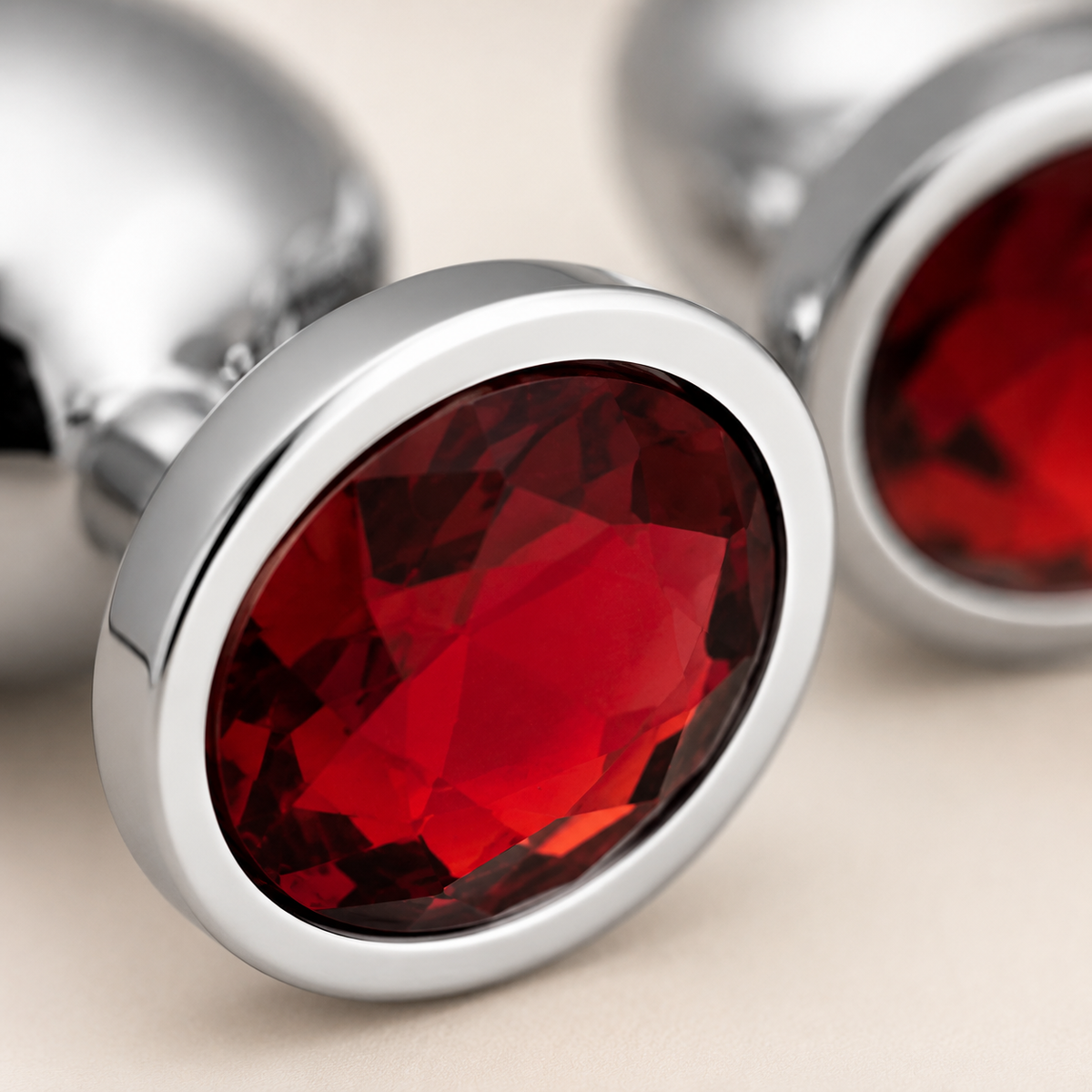 Close-up van de rode kristallen en gepolijste zilveren afwerking van de FlexToyz buttplug set