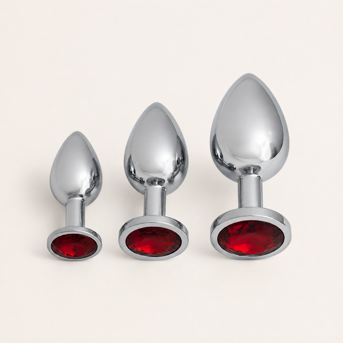 Zilveren FlexToyz buttplug set met drie maten en rode diamant op neutrale achtergrond