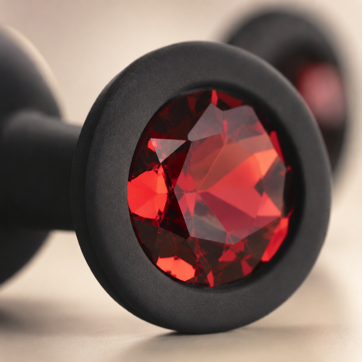Close-up van de rode diamant en matte zwarte siliconen afwerking van de FlexToyz buttplug set