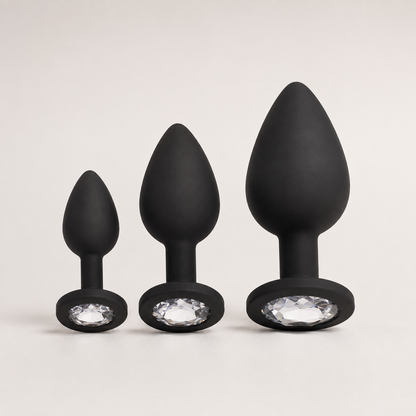 FlexToyz zwarte siliconen buttplug set met witte diamant in drie maten op neutrale achtergrond