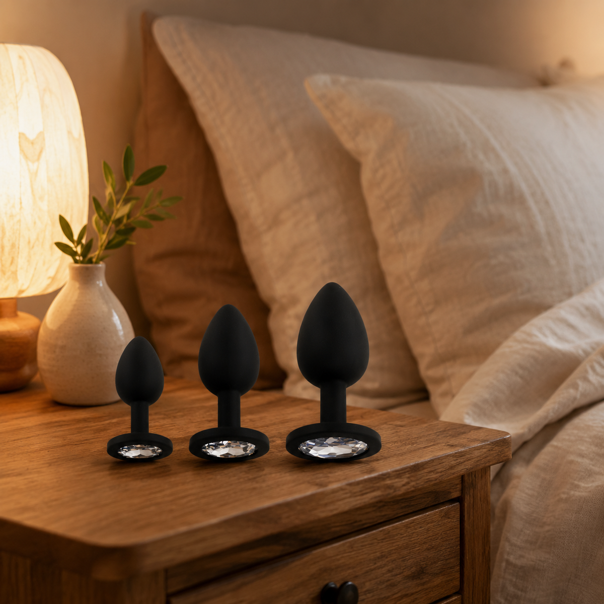 FlexToyz zwarte siliconen buttplug set met witte diamant op warm houten nachtkastje