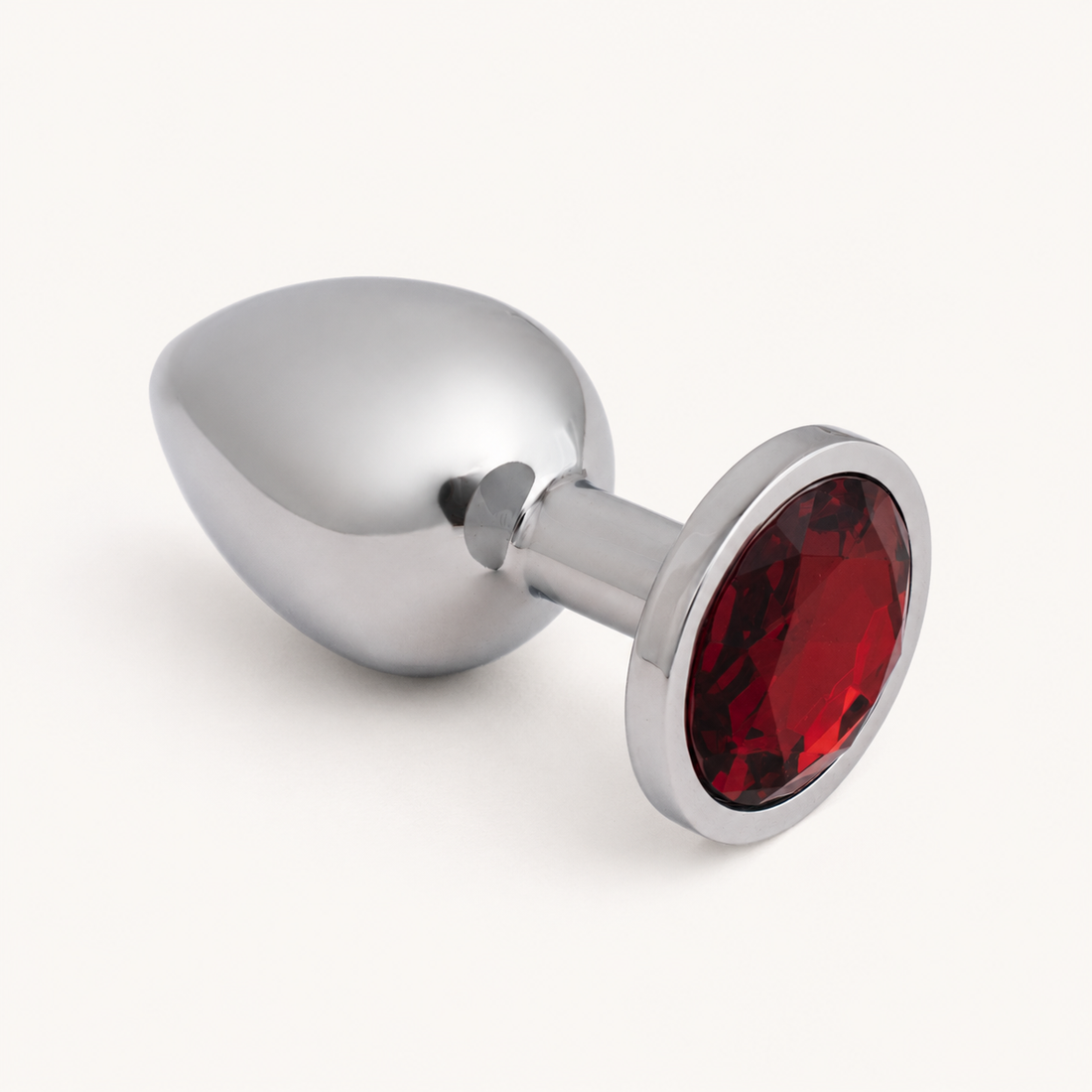 Middelgrote zilveren FlexToyz buttplug met rode diamant op neutrale achtergrond