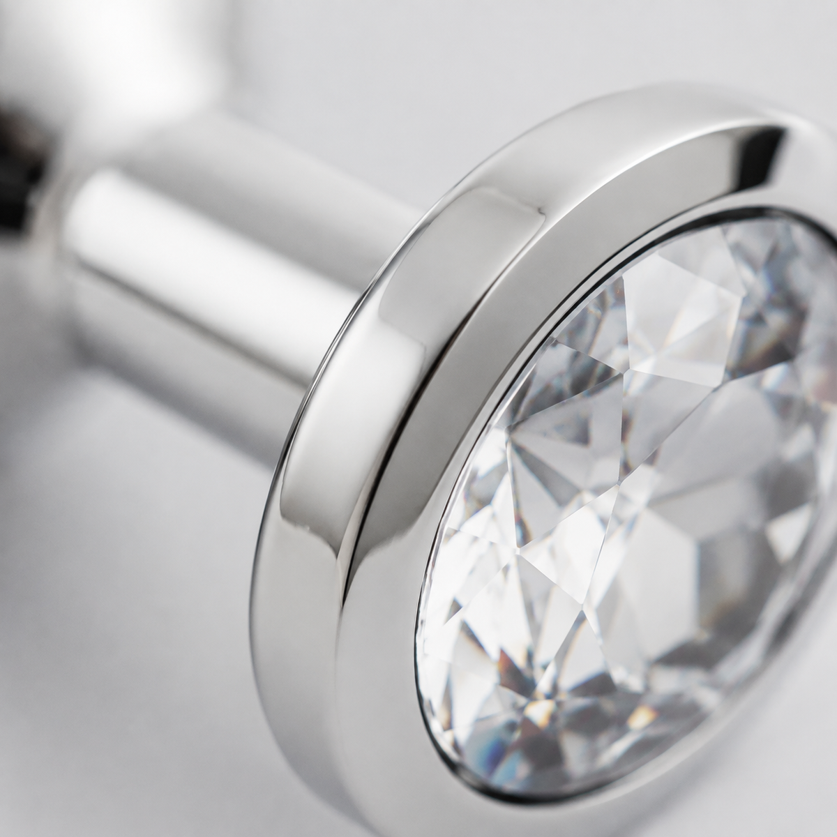 Macrodetail van de witte kristalfacetten en zilveren rand van de middelgrote buttplug