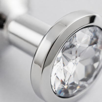 Macrodetail van de witte kristalfacetten en zilveren rand van de middelgrote buttplug