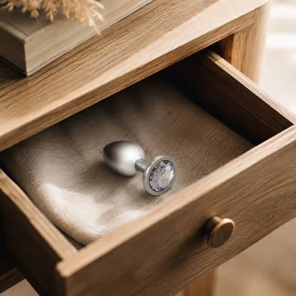 Middelgrote zilveren buttplug met witte diamant stijlvol opgeborgen in een nachtkastlade