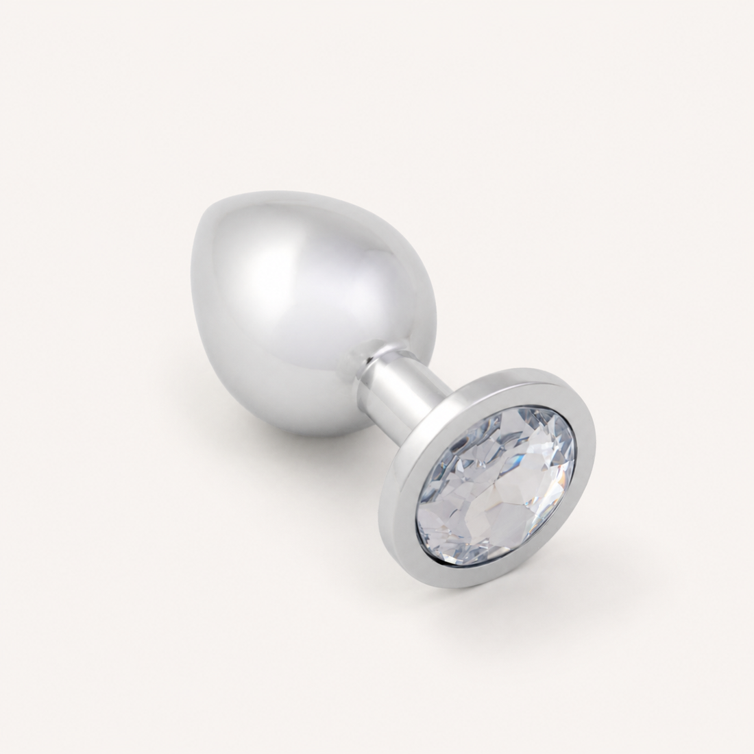 Middelgrote zilveren FlexToyz buttplug met witte diamant op neutrale achtergrond