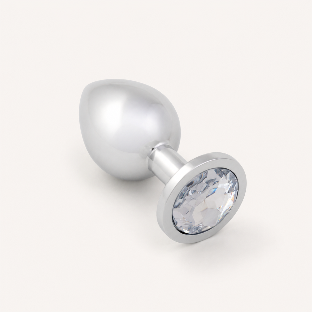 Middelgrote zilveren FlexToyz buttplug met witte diamant op neutrale achtergrond