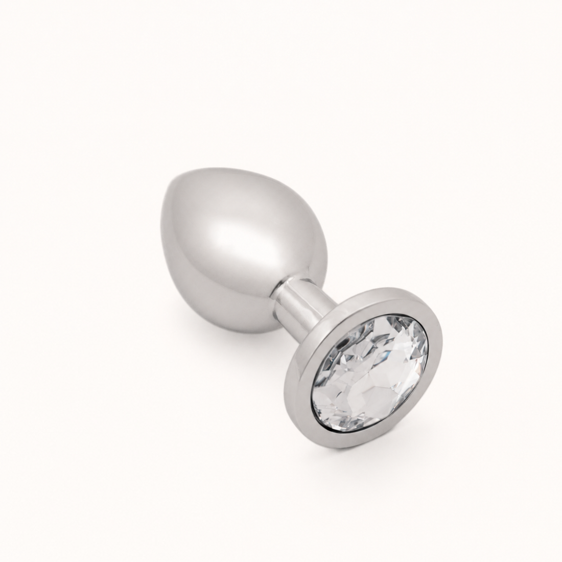Kleine zilveren FlexToyz buttplug met witte diamant op neutrale achtergrond