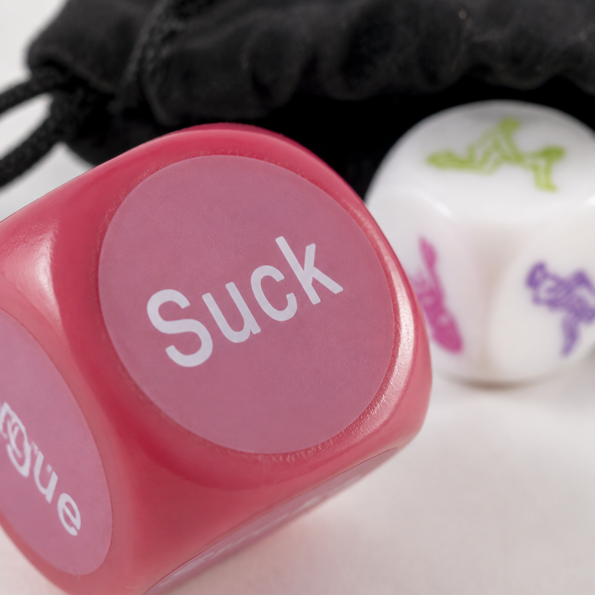 Macrodetail van glossy roze FlexToyz Kama Sutra actiedobbelsteen met afgeronde hoeken