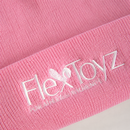 Macrodetail van roze ribbreisel en wit geborduurd FlexToyz logo op de beanie