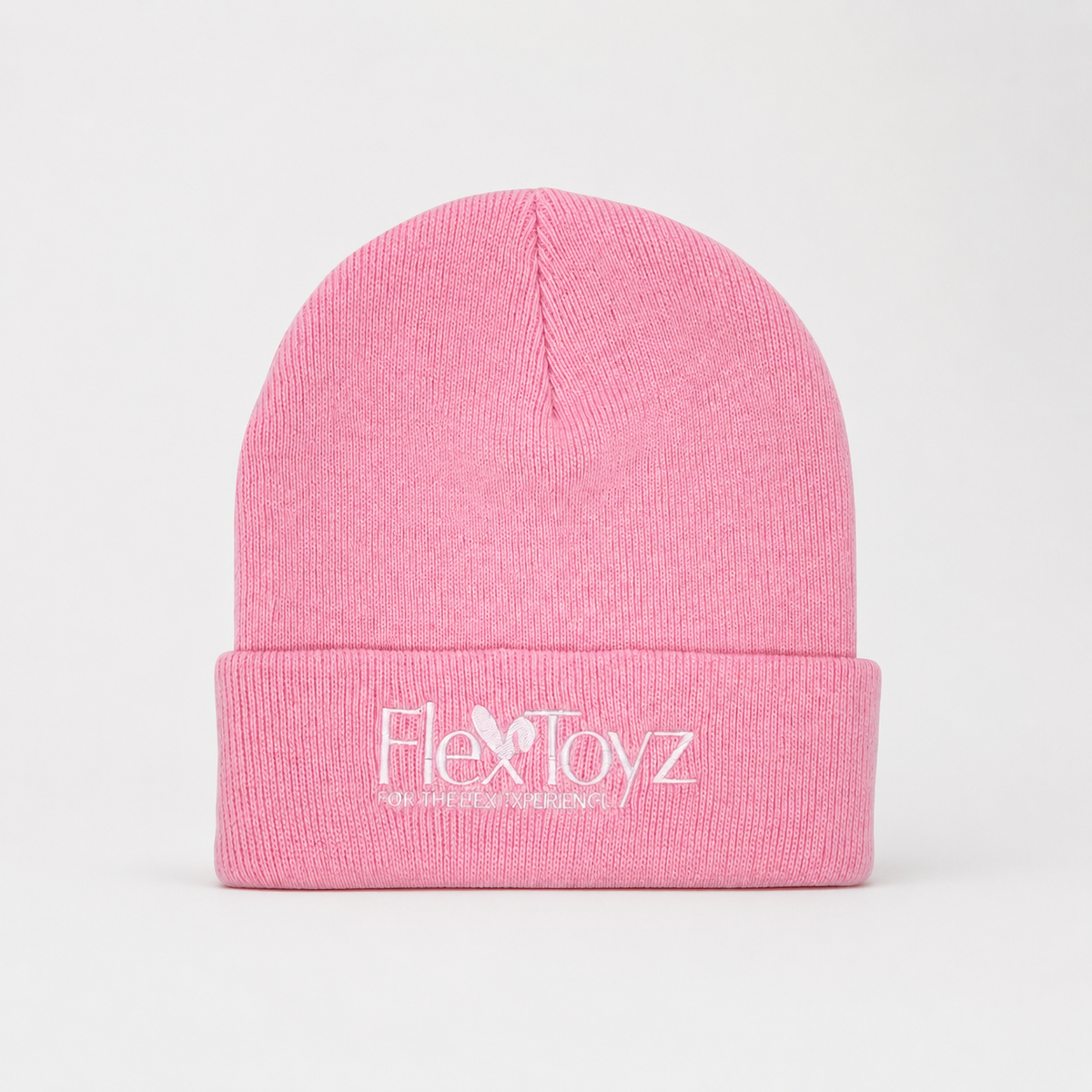 Roze FlexToyz beanie met wit geborduurd logo op neutrale studioachtergrond