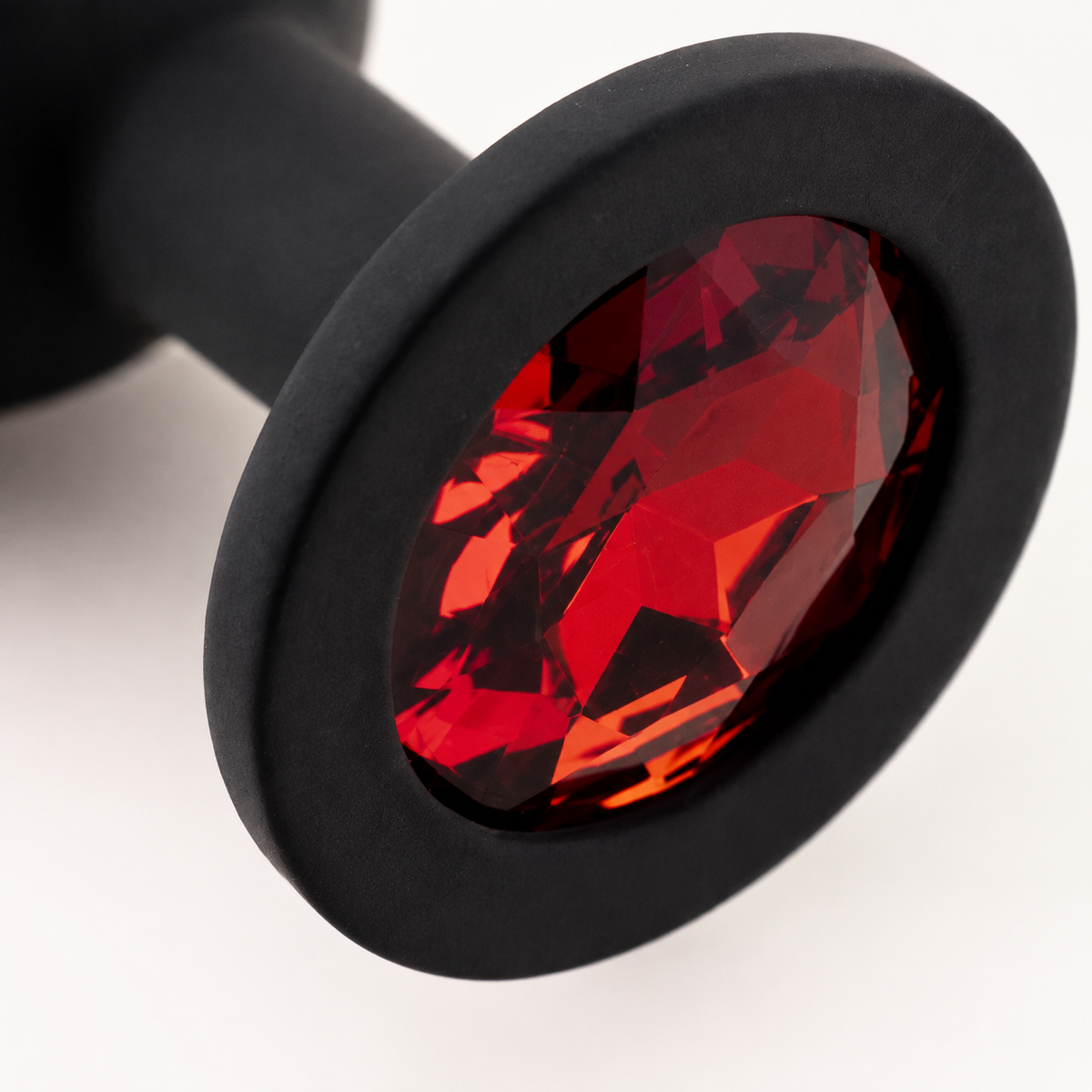 Macrodetail van rode diamant en matzwarte siliconen basis van FlexToyz buttplug Large