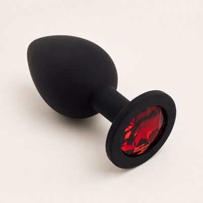 Zwarte siliconen FlexToyz buttplug Large met rode diamant op witte achtergrond