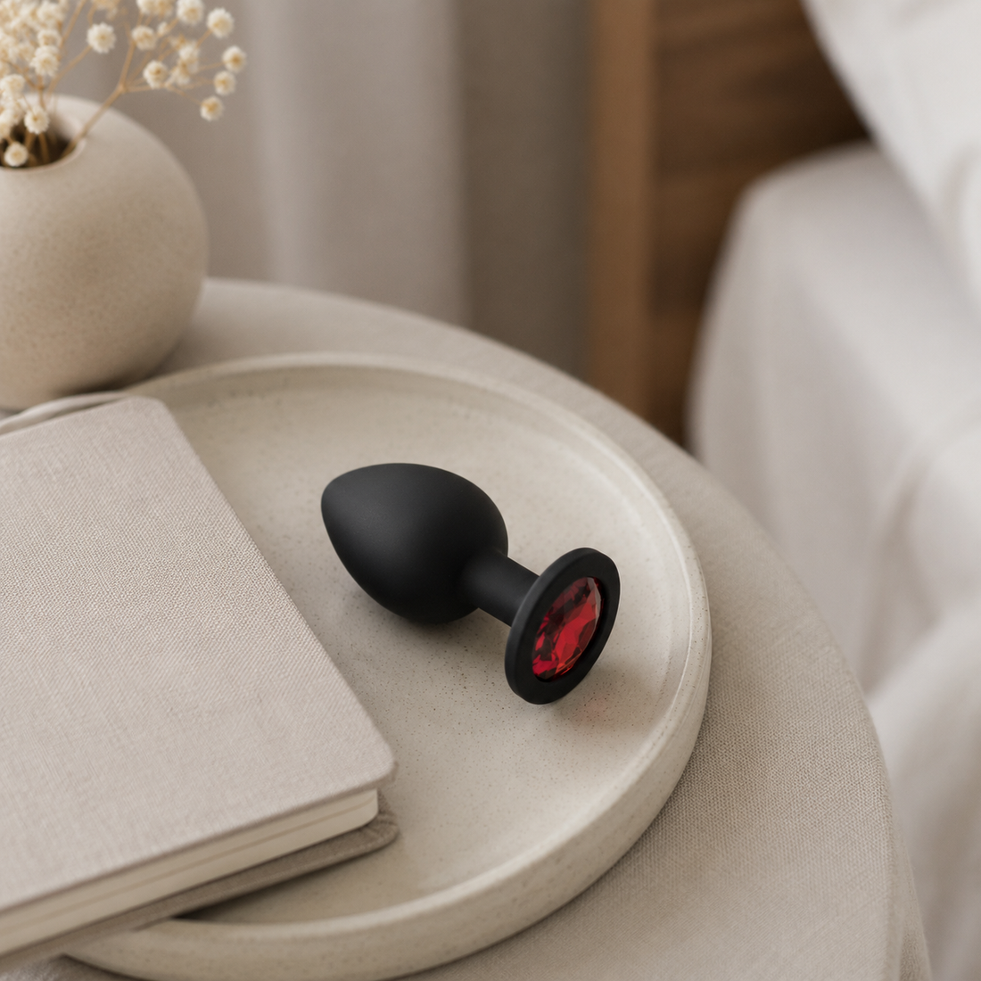 Zwarte siliconen FlexToyz buttplug Large naast A5-notitieboek voor schaalweergave