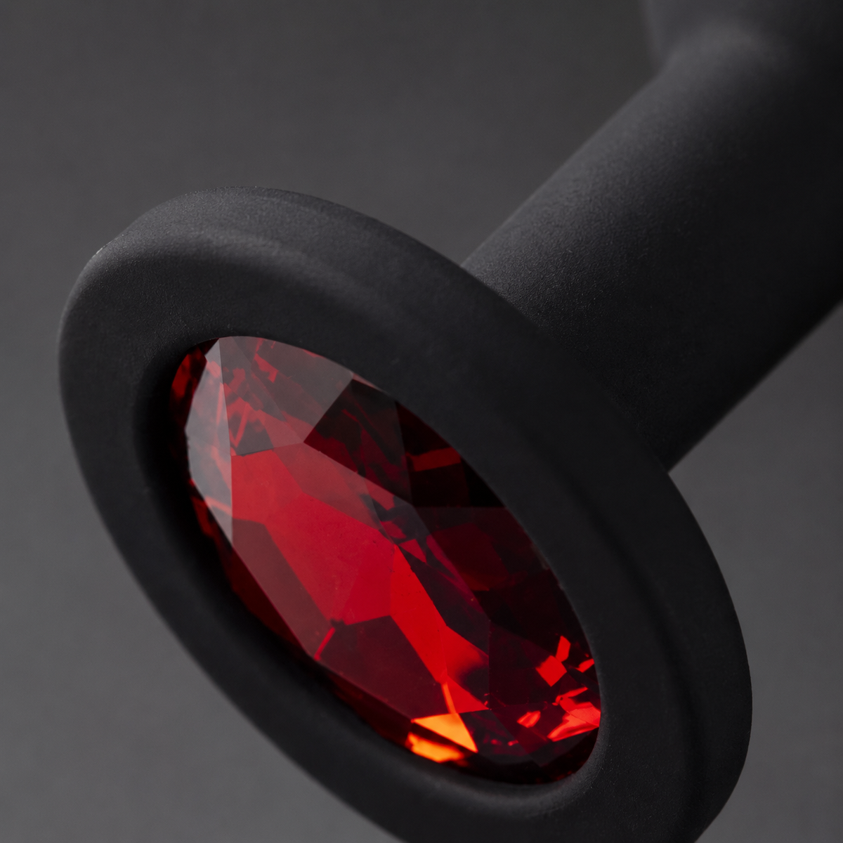 Macrodetail van rode diamant, brede basis en matzwarte siliconen van FlexToyz buttplug Medium