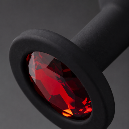 Macrodetail van rode diamant, brede basis en matzwarte siliconen van FlexToyz buttplug Medium