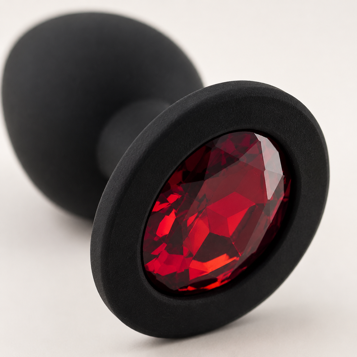 Macrodetail van rode diamant en matzwarte siliconen basis van FlexToyz buttplug Small