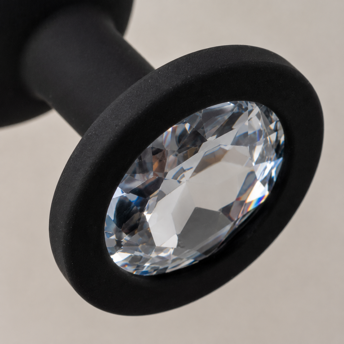 Macrodetail van witte diamant en matzwarte siliconen basis van FlexToyz buttplug Large