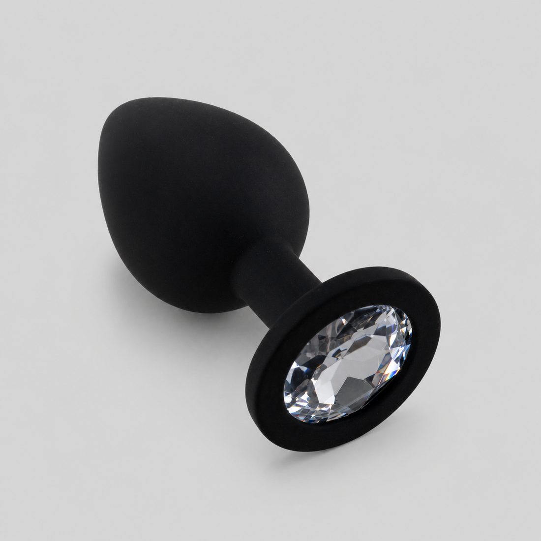Zwarte siliconen FlexToyz buttplug Medium met witte diamant op lichtgrijze achtergrond