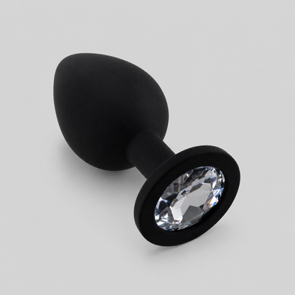 Zwarte siliconen FlexToyz buttplug Medium met witte diamant op lichtgrijze achtergrond