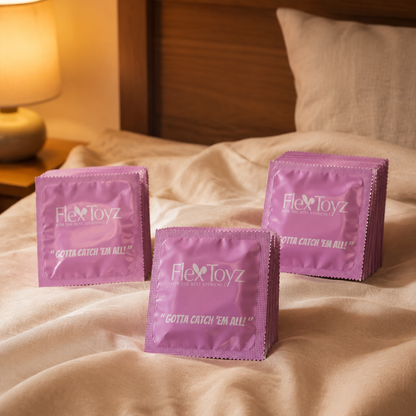Drie stapels roze FlexToyz condoomverpakkingen op warm ivoorkleurig bedlinnen