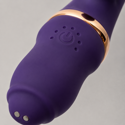 Macrodetail van bediening, laadcontacten en goudkleurige ring van paarse FlexToyz Rabbit Vibrator