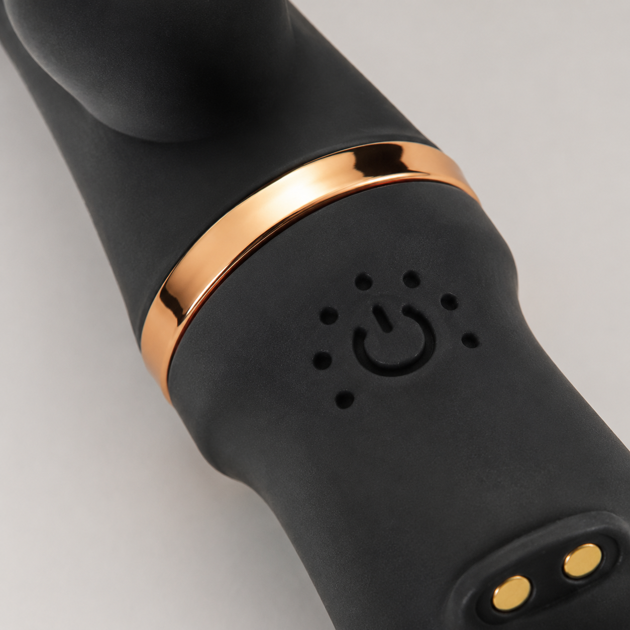 Macrodetail van bediening, laadcontacten en goudkleurige ring van zwarte FlexToyz Rabbit Vibrator