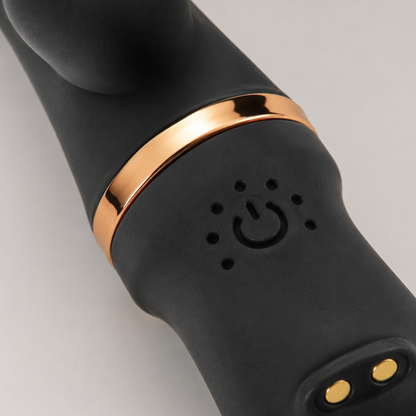 Macrodetail van bediening, laadcontacten en goudkleurige ring van zwarte FlexToyz Rabbit Vibrator