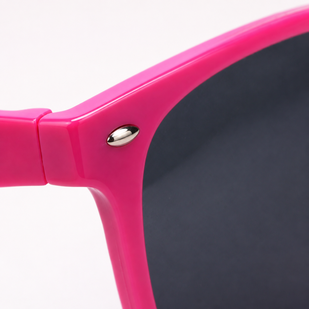 Macrodetail van glanzend roze frame, zilveren stud en donker glas van FlexToyz zonnebril